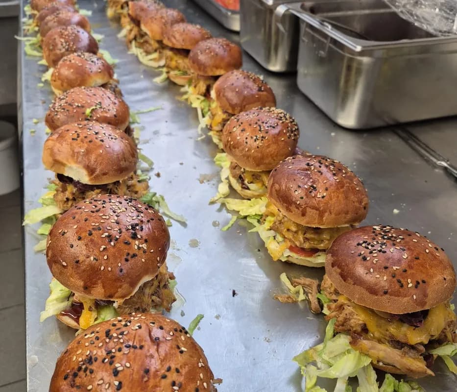 Plechy s připravenými mini burgery při chystání cateringu